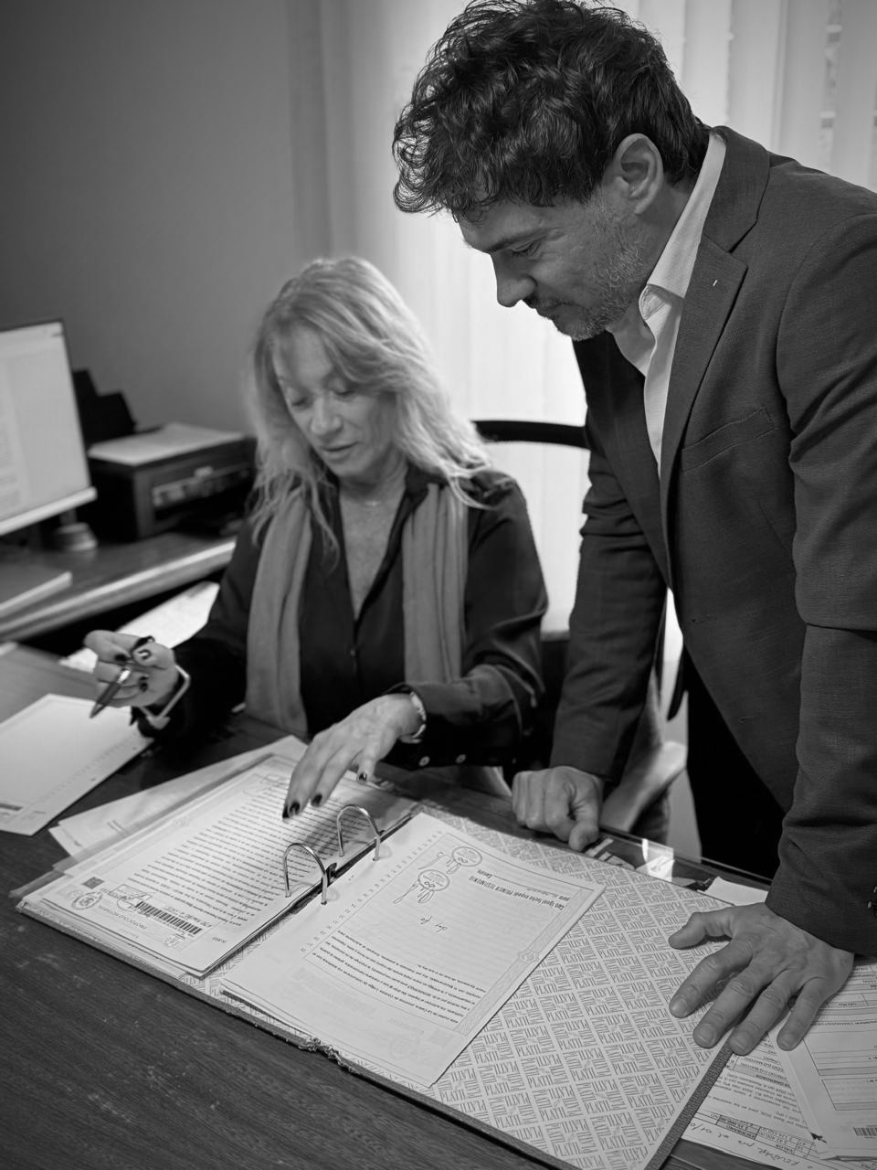 Marcela Peralta y Álvaro Nadra revisando documentación en la escribanía